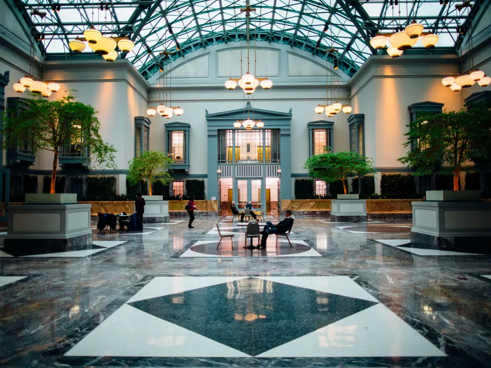 Hotel lobby with a glass roof and trees